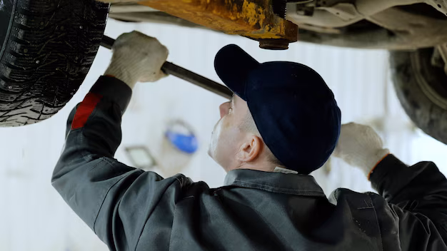Mechanic repairing undercarriage of car